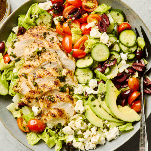 Salade de poulet grillé avec avocat, concombre, tomates et feta.