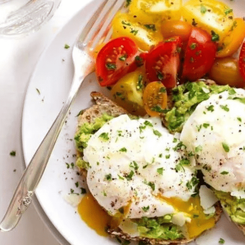 Toast à l’avocat avec œufs pochés et tomates cerises colorées.